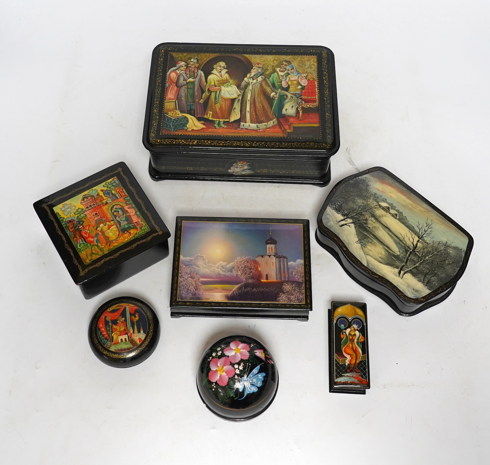 Seven Russian lacquer boxes, largest 21.5cm wide. Condition - fair to good